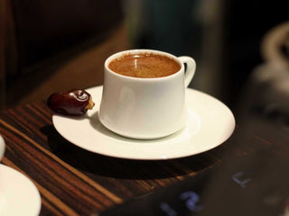 an ibrik cezce coffee on a white sufi cup set with a date